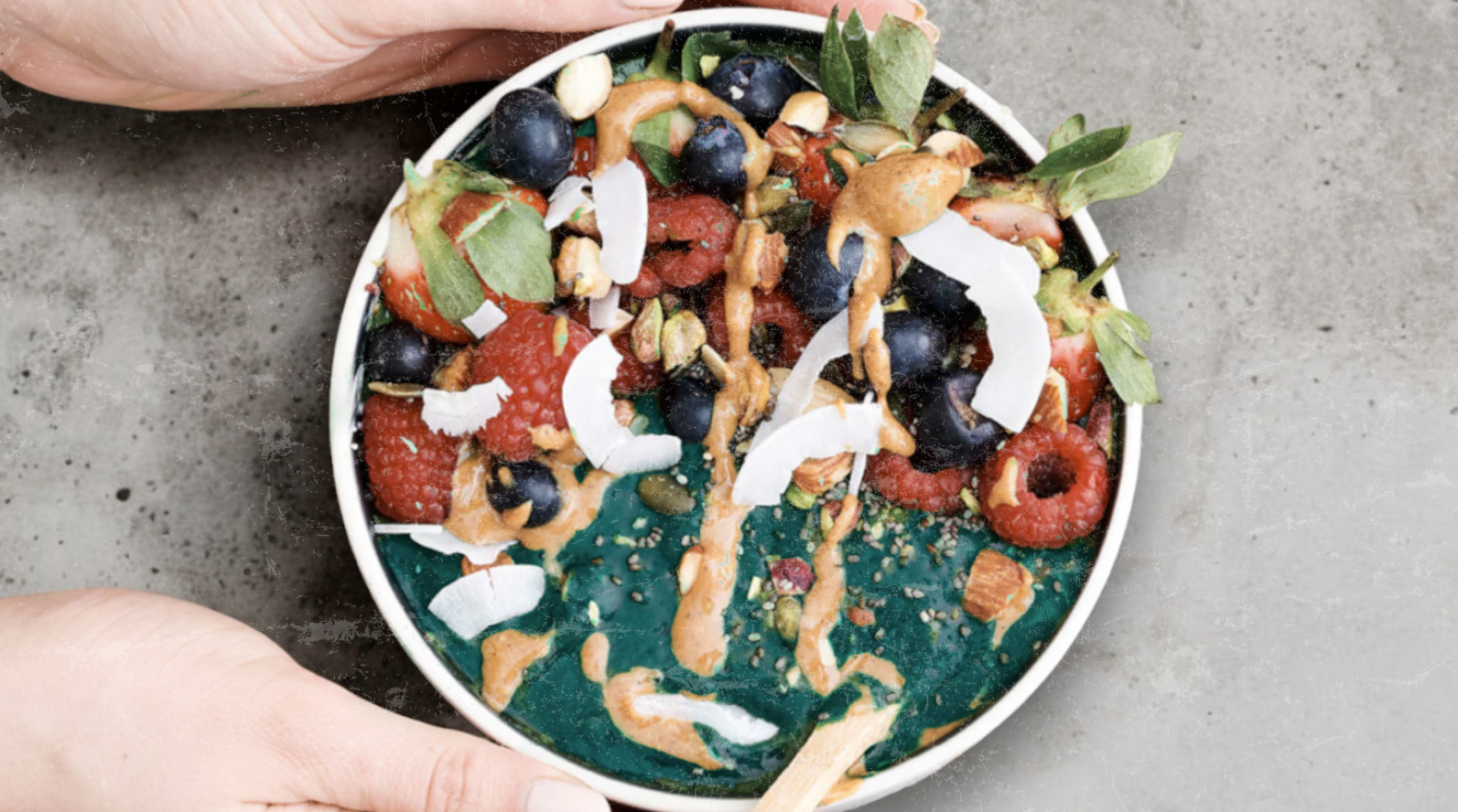 Elyxar Detox Smoothie Bowl topped with raspberries, blueberries, coconut flakes, nut butter, and seeds — a nutrient-packed, antioxidant-rich superfood meal.