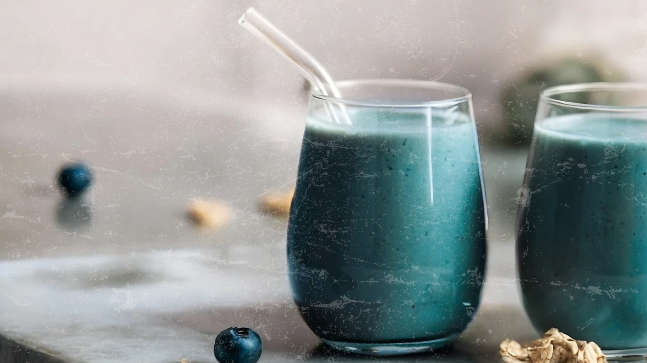 Blue-green superfood smoothie with glass straw, blueberries, and walnuts — made with Elyxar by Apotheka Superfoods for clean energy and gut health.