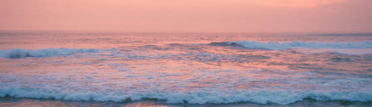 Gentle ocean waves under a pink sunrise — symbolizing the clean, calming, and restorative energy behind Elyxar by Apotheka Superfoods.
