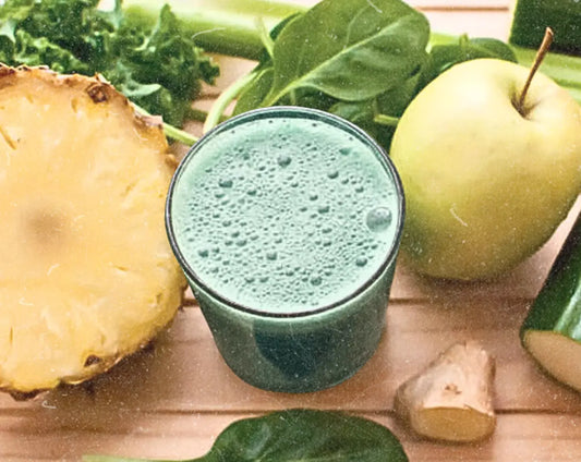 Green Glow Detox Smoothie with pineapple, cucumber, green apple, lemon, and leafy greens blended with Elyxar for energy, digestion, and cleansing support.