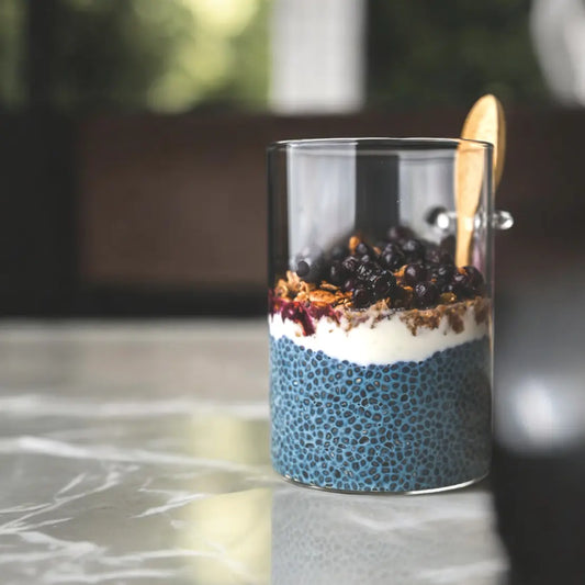 Blueberry Cobbler Chia Pudding layered with Elyxar, cashew cream, and fresh berries — a gut-friendly, energizing breakfast by Apotheka Superfoods.