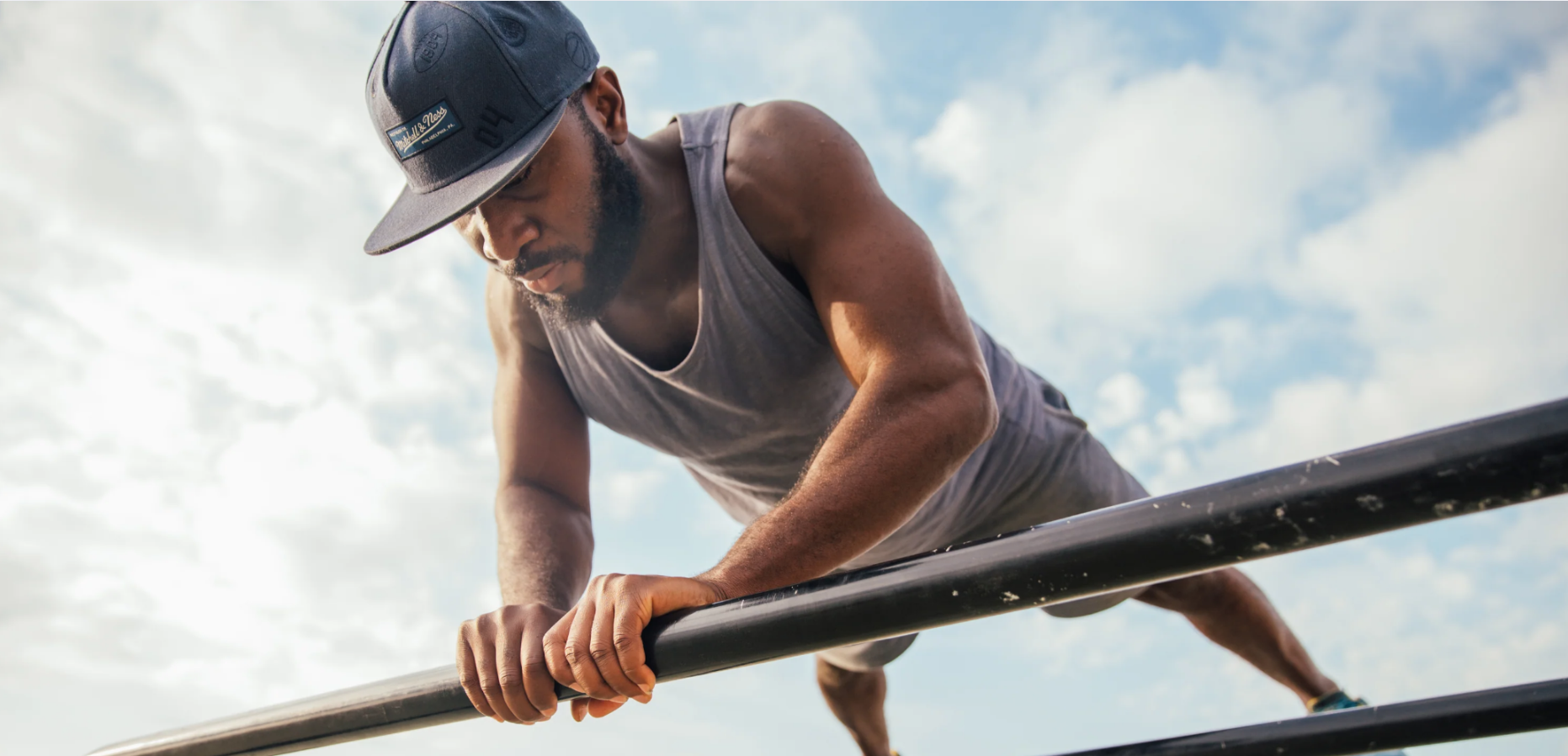 Person standing triumphant on mountain peak — symbolizing the strength, clarity, and vitality supported by Elyxar from Apotheka Superfoods.