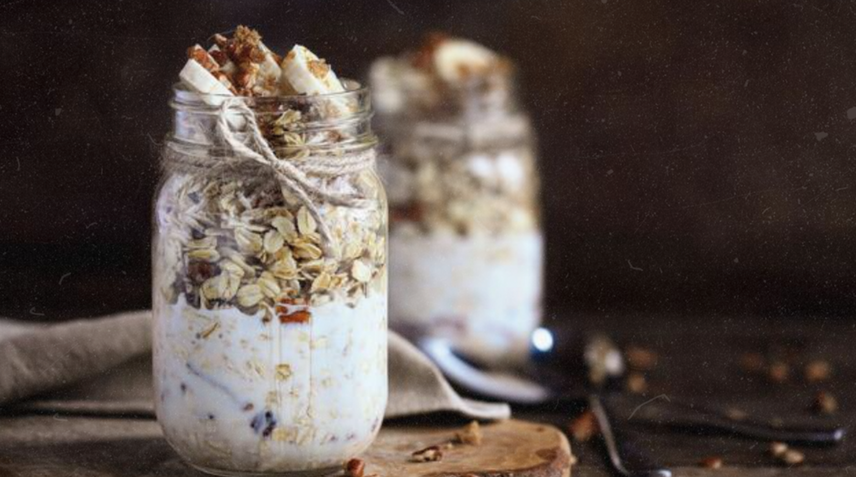 Banana bread overnight oats layered in jars with oats, banana, granola, and Elyxar Daily Superfood Complex for a creamy, functional breakfast.